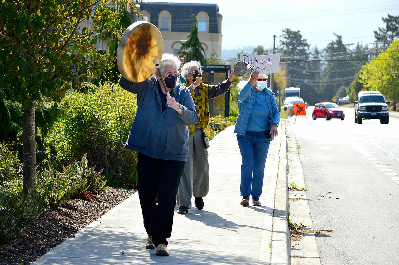 Libby Atkins of Port Townsend leads a masked band of percussionists up Sheridan Street past Jefferson Healthcare hospital on Thursday. The women were part of a gratitude parade that included classic cars, bicyclists and bell-jinglers. (Diane Urbani de la Paz/Peninsula Daily News)