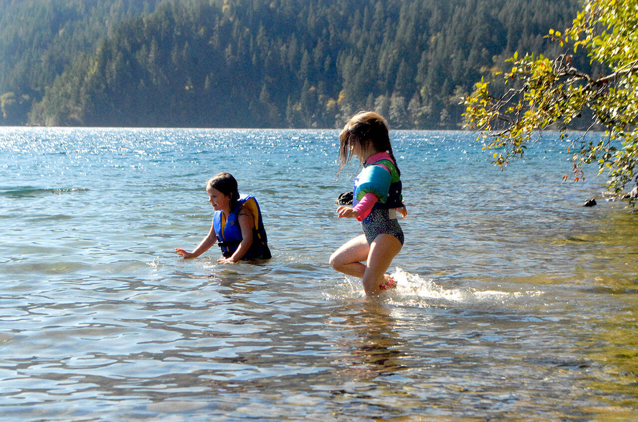 Normajane Goodfellow, 4, left, and Minue Garling, 5, both of Port Angeles, cavort in the waters of Lake Crescent in Olympic National Park over the weekend. The youth were on a family outing to East Beach Road. (Keith Thorpe/Peninsula Daily News)
