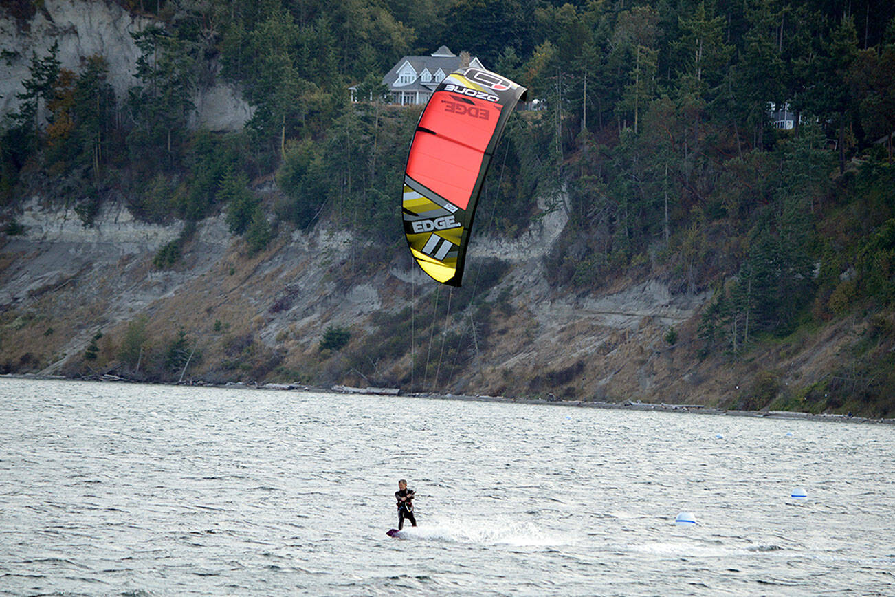 In what he called a “good frisky breeze,” Josh Porter of Port Townsend kiteboards across the Salish Sea beside Fort Worden State Park. (Diane Urbani de la Paz/Peninsula Daily News)