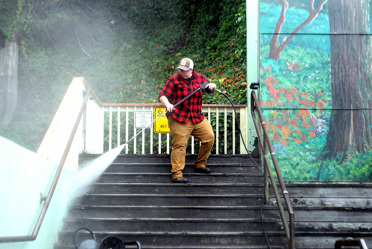 Port Angeles Parks & Recreation Department employee Jessica Adams pressure washes the Laurel Street stairs behind the Conrad Dyar Memorial Fountain in downtown Port Angeles on Wednesday. (Keith Thorpe/Peninsula Daily News)