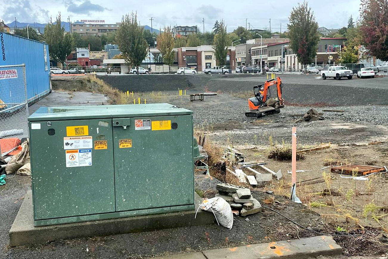 A backhoe driver works Thursday at the Elwha Hotel construction site in downtown Port Angeles while awaiting removal of an electrical switch box, foreground. (Paul Gottlieb/Peninsula Daily News)