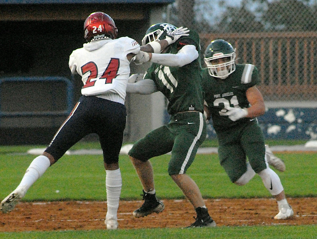 Keith Thorpe/Peninsula Daily News Port Angeles Ty Bradow, center, fends off Kennedy Catholics XeRee Alexander as Roughrider Daniel Cable tries to slip past with the ball on Friday at Port Angeles Civic Field.