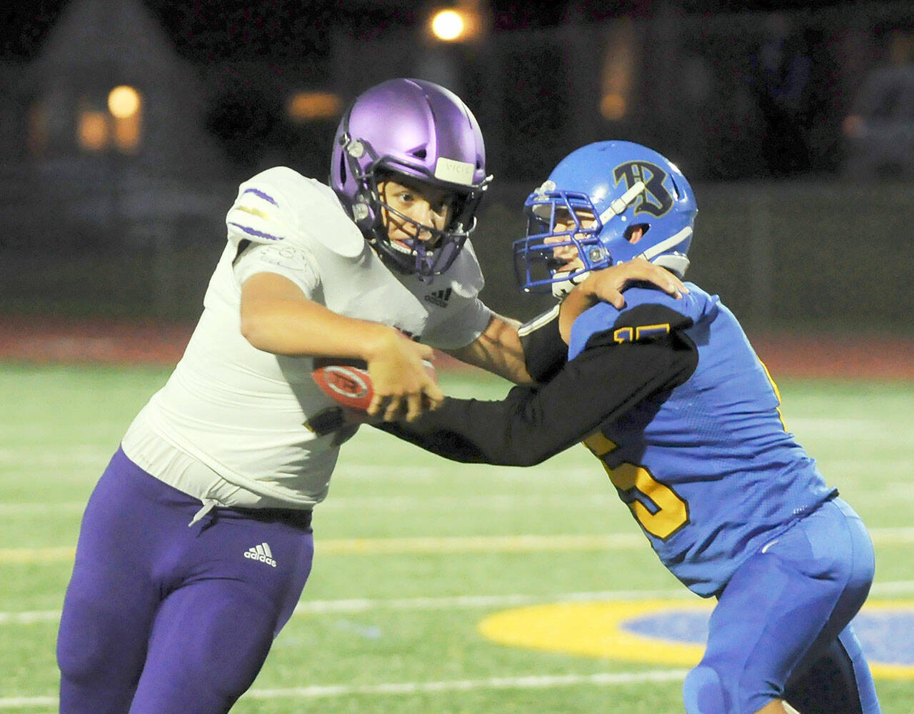 Michael Dashiell/Olympic Peninsula News Group
Sequim quarterback Lars Wiker, left, tries to avoid the grasp of a Bremerton defender in the Wolves' 35-29 loss at Bremerton on Thursday.