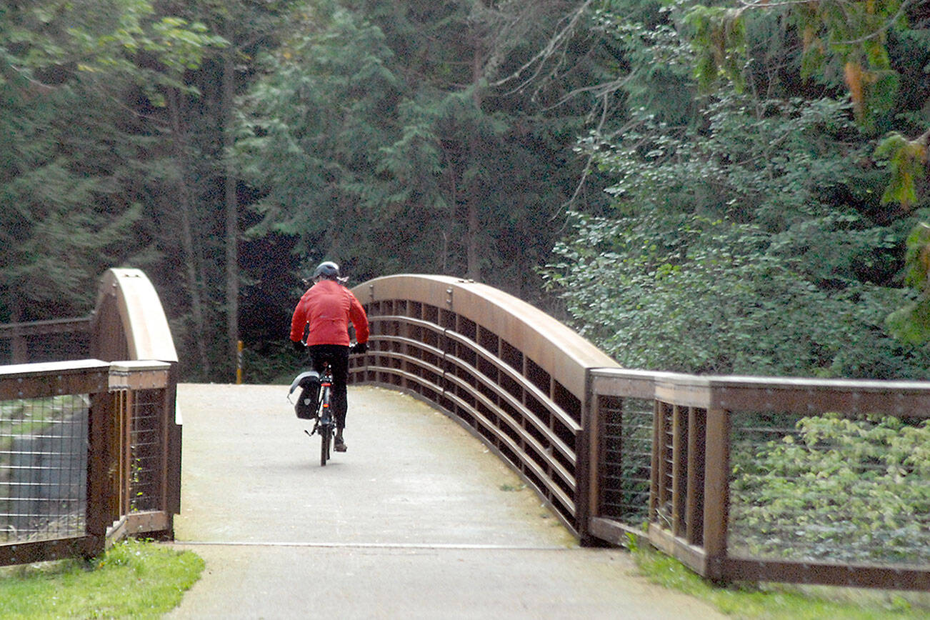 A bicyclist makes his way across a bridge on the Olympic Discovery Trail at Sequim Bay State Park on Saturday. The 210-foot-long bridge, which spans a small stream that passes through the park, was constructed in 2017. (Keith Thorpe/Peninsula Daily News)
