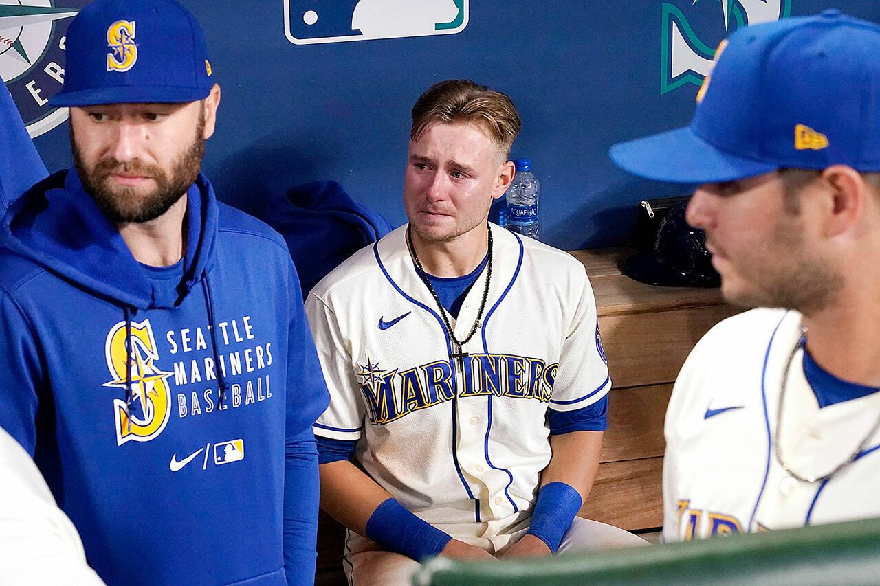 Seattle Mariners’ Jarred Kelenic, center, sits in the dugout after his team lost to the Los Angeles Angels in a baseball game Sunday in Seattle. (Elaine Thompson/The Associated Press)