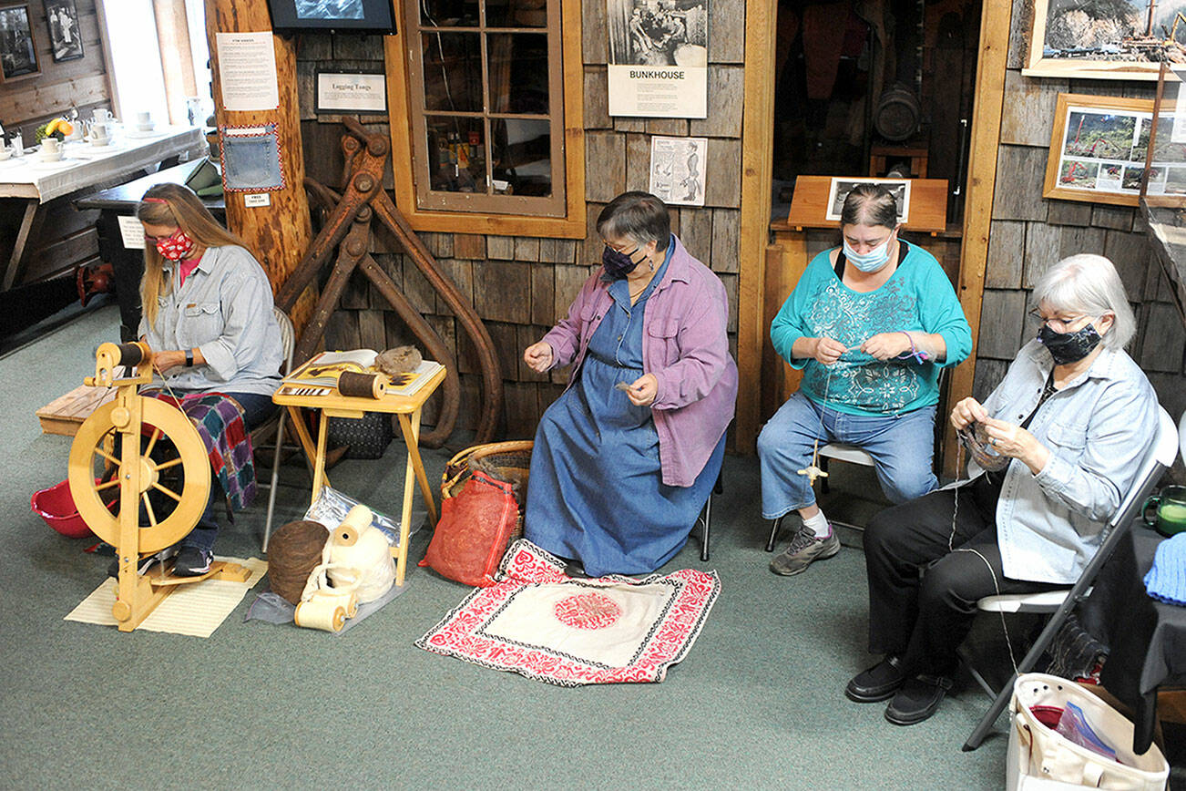 From left, Jennifer Pelikan, Sue Shane, Jessica Mishler, and Linda Offutt are shown Saturday morning at the Forks Timber Museum demonstrating Spinning, knitting and sewing.  Photo by Lonnie Archibald.