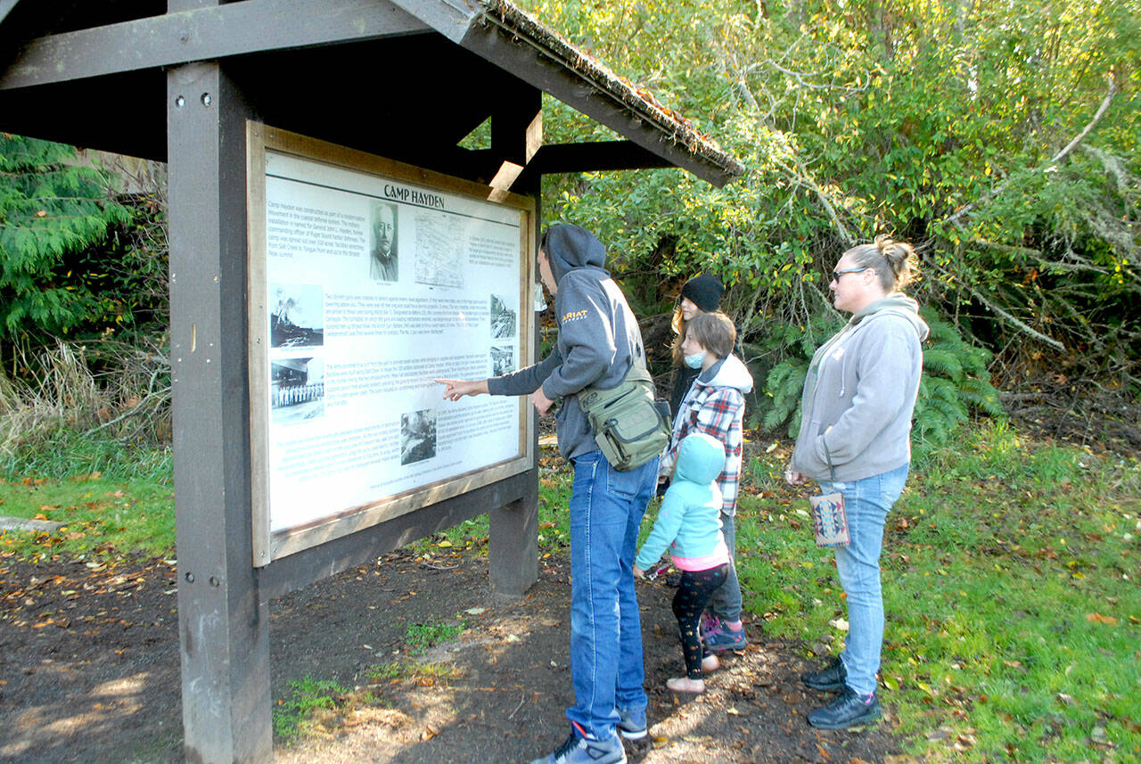 Members of the Pease family of Sequim, from left, father, Craig, children Addison, 12, Alayna, 10 and Alivia, 3, and mother, Bambi, examine an information kiosk at Salt Creek Recreation Area north of Joyce last week. The group was exploring places on the North Olympic Peninsula. (Keith Thorpe/Peninsula Daily News)