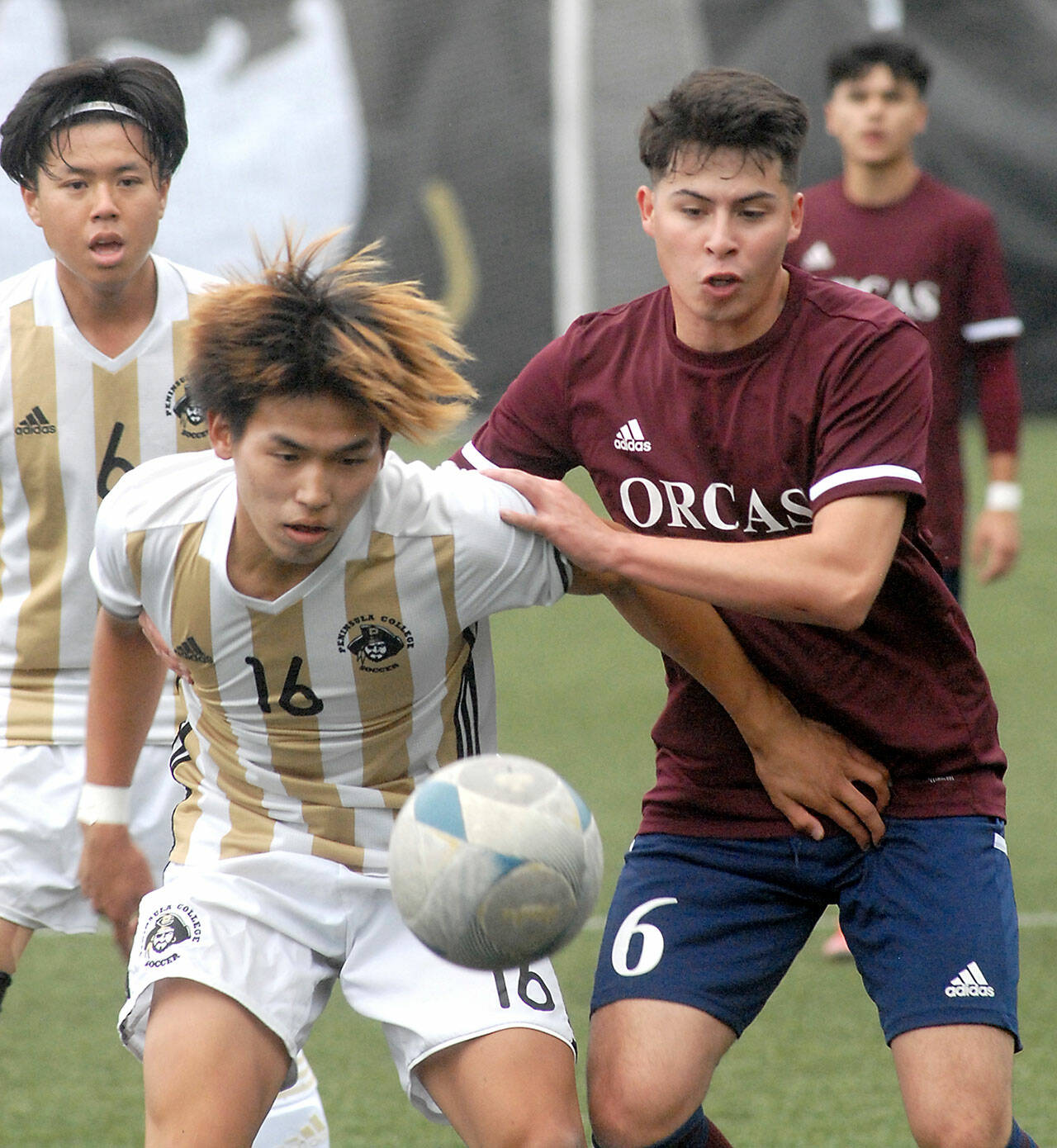 Peninsulas Hayahide Sakamoto, front left, and Whatcoms Juan Obeso eye a loose ball on Saturday at Peninsula College. Behind Sakamoto is teammate Jeong Hyun Kang. (Keith Thorpe/Peninsula Daily News)