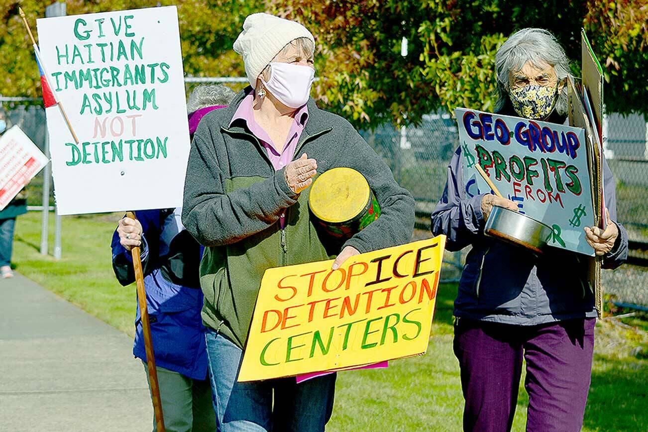 Katie Franco, center, and Libby Palmer of Port Townsend demonstrate support for Haitian asylum seekers outside the Tacoma Northwest Detention Center on Sunday. (Diane Urbani de la Paz/Peninsula Daily News)