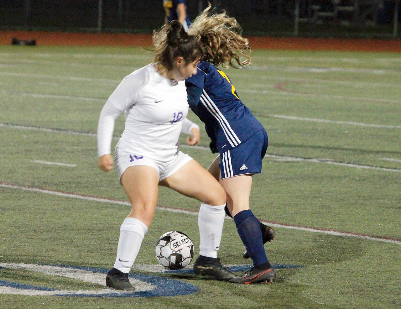 Sequim’s Samantha Gonzalez, left, gets tangled up with Bainbridge’s Gabby Weis at midfield during a 1-0 loss to the Spartans on Thursday. (Mark Krulish/Kitsap News Group)