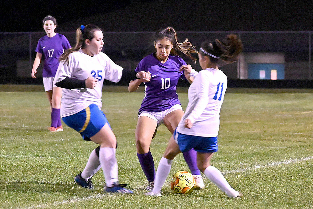 With teammate Kaia Lestage (left) looking on, Sequim’s Jennyfer Gomez (10) vies for possession in the Wolves’ 6-0 win Tuesday night against visiting Bremerton. (Michael Dashiell/Olympic Peninsula News Group)