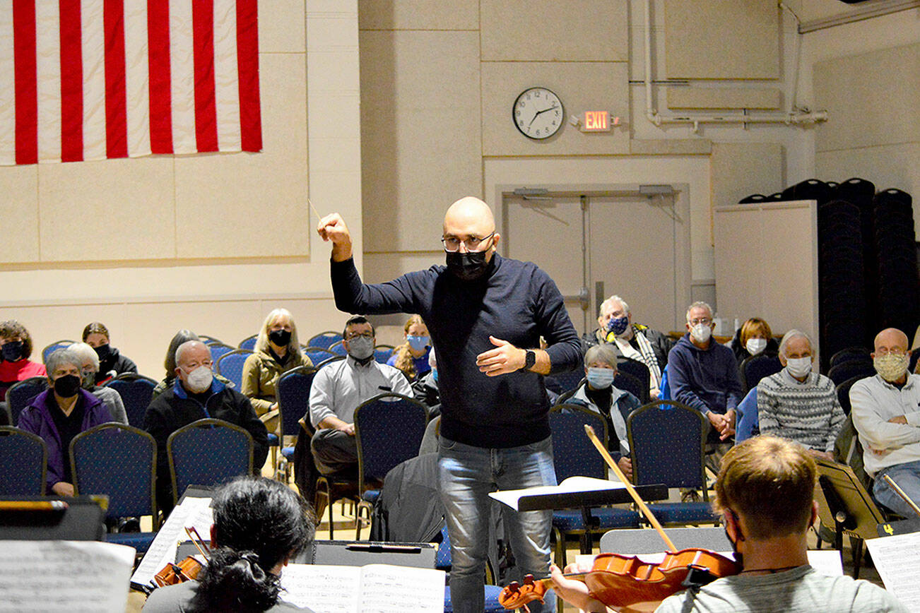 Conductor Tigran Arakelyan rehearses Friday night with the Port Townsend Symphony Orchestra before a small live audience at the American Legion Hall. Today the ensemble will give its first public performance since early 2020; the 2 p.m. concert is sold out, but the orchestra plans another one on Dec. 4. Information can be found at PTsymphony.org. Diane Urbani de la Paz/Peninsula Daily News