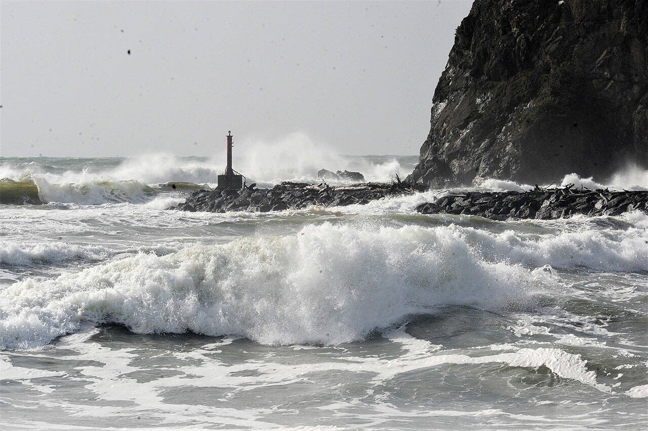 Waves and foam erupt from the Pacific Ocean during high tide at the mouth of the Quillayute River in La Push. In the distance is James Island and the marker light at the river’s mouth. Strong winds and rain pummeled the Peninsula on Sunday. (Lonnie Archibald/for Peninsula Daily News)