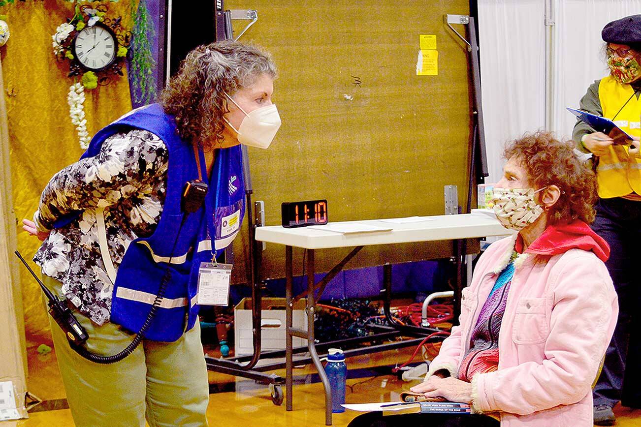 Volunteer nurse Karen Easterly-Behrens of Port Ludlow, left, talks with Eliana Rose of Port Townsend at Saturday’s Pfizer booster clinic at Quilcene School. The county Department of Emergency Management worked with dozens of volunteers to organize the clinic. (Diane Urbani de la Paz/Peninsula Daily News)