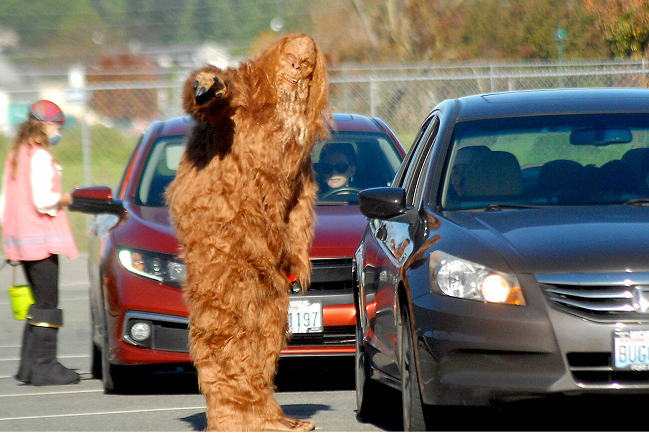 Bigfoot, portrayed by YMCA wellness couch Stan Dame, directs trick-or-treat traffic during Saturday's Halloween drive through at the YMCA of Sequim. Those seeking treats were offered the opportunity to make their way around the facility's parking lot as costumed characters delivered curb-side confections.