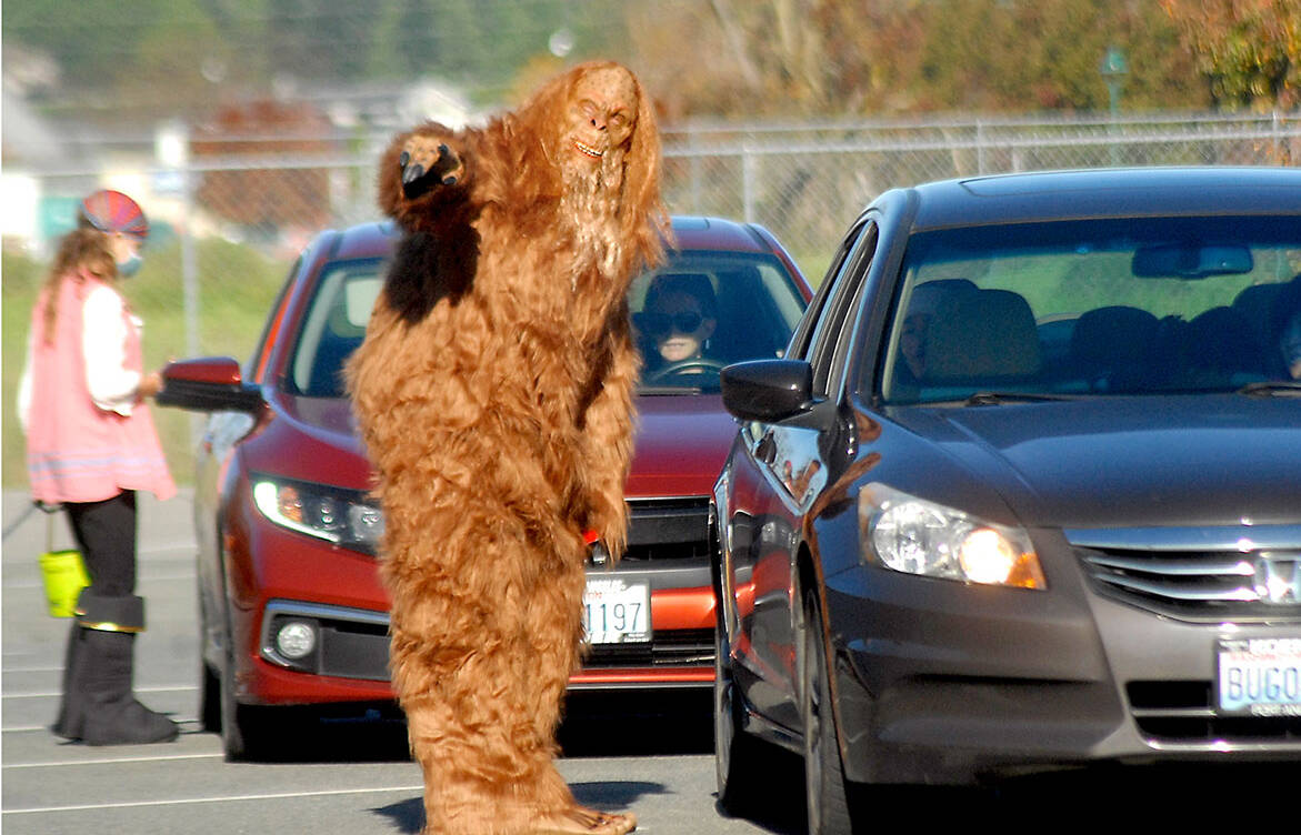 Bigfoot, portrayed by YMCA wellness coach Stan Dame, directs trick-or-treat traffic during Saturday's Halloween drive through at the YMCA of Sequim. Those seeking treats were offered the opportunity to make their way around the facility's parking lot as costumed characters delivered curb-side confections.