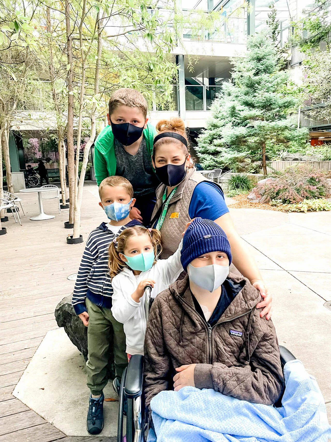 Five of the six-member Ake family pose outside the Seattle Children’s hospital. Emerson Ake, front, is battling leukemia with quiet courage and good humor, and his family has temporarily moved from Sequim to stay together. (Ake family)