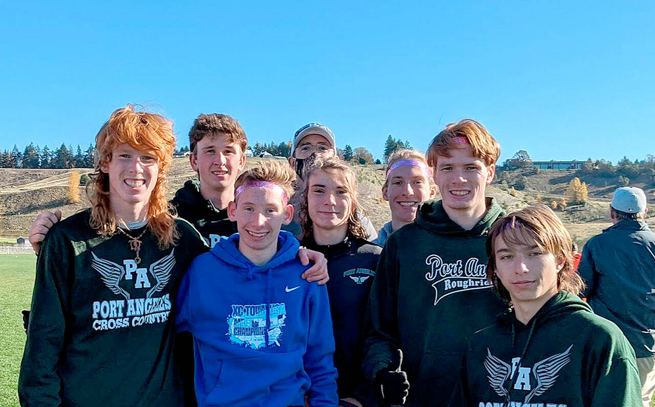 Port Angeles cross-country runners, from left Jack Gladfelter, Naaman McGuffey, Langdon Larson, Coach Rodger Johnson, Kowen Kasten, Josh Gavin, Jason Gladfelter and Max Baeder won the District 3 championship this weekend and qualified for the state 2A meet. (Courtesy photo)