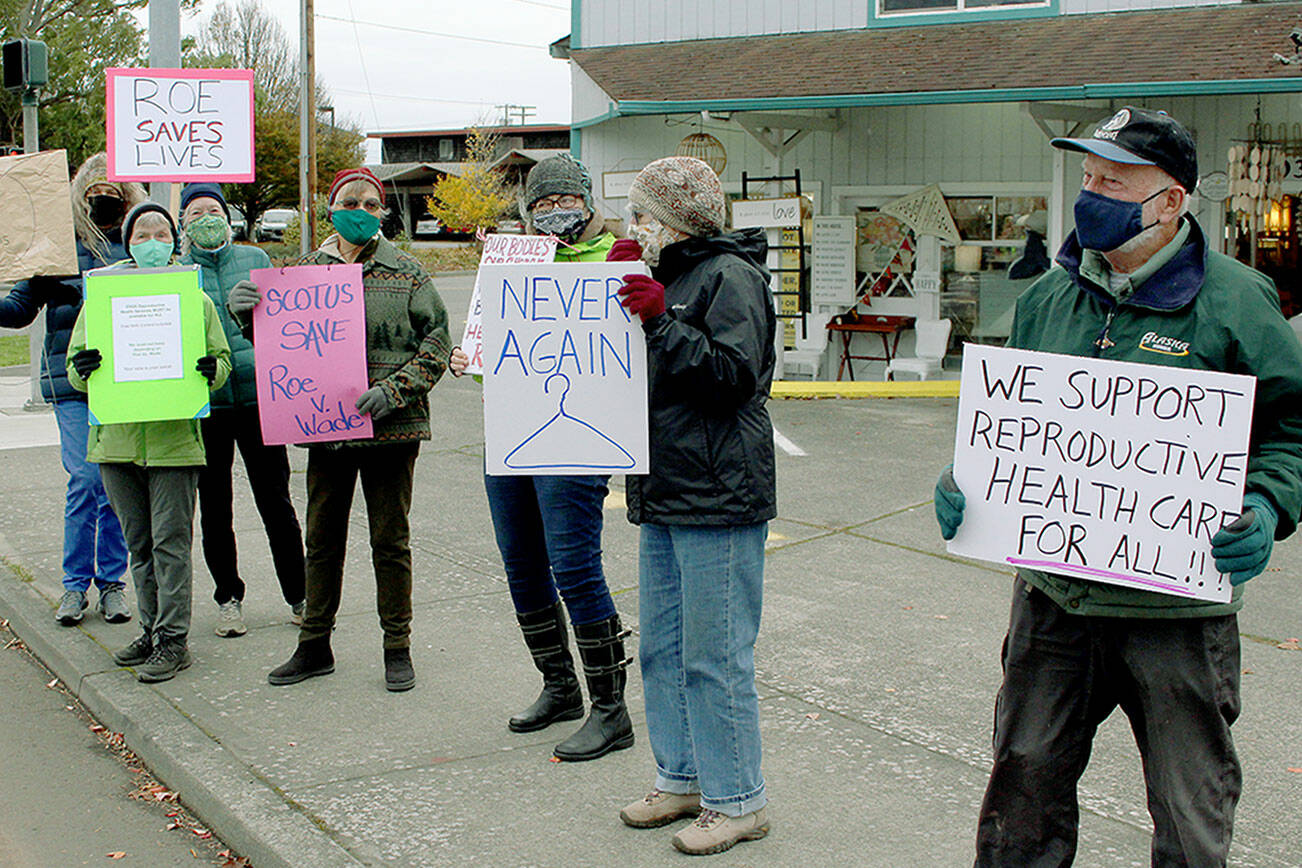 More than 20 members of Indivisible Port Townsend line each side of East Sims Way at Kearney Street in a rally Monday afternoon supporting the Roe v. Wade U.S. Supreme Court decision allowing pregnant women to receive an abortion without excessive government restrictions. The rally coincides with the Supreme Court allowing arguments regarding the new abortion laws enacted by Texas lawmakers that bans most abortions after six weeks of pregnancy. (Zach Jablonski/Peninsula Daily News)