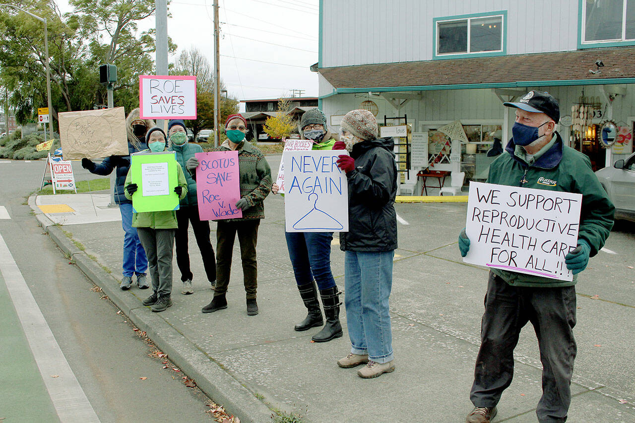 More than 20 members of Indivisible Port Townsend line each side of East Sims Way at Kearney Street in Port Townsend Monday afternoon to rally in support of the 1973 U.S. Supreme Court decision Roe v. Wade, guaranteeing women the right to receive a safe abortion without excessive government restrictions. The Supreme Court heard arguments Monday regarding the new abortion law enacted in September by Texas lawmakers that bans most abortions after six weeks of pregnancy. (Zach Jablonski/Peninsula Daily News)