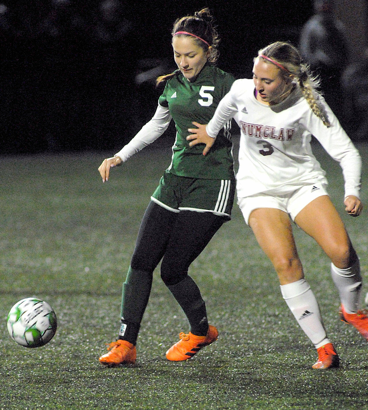Port Angeles’ Mia Gagnon, left, and Enumclaw’s Lauren Boger battle for the ball during Tuesday night’s playoff game at Wally Sigmar Field in Port Angeles. (Keith Thorpe/Peninsula Daily News)