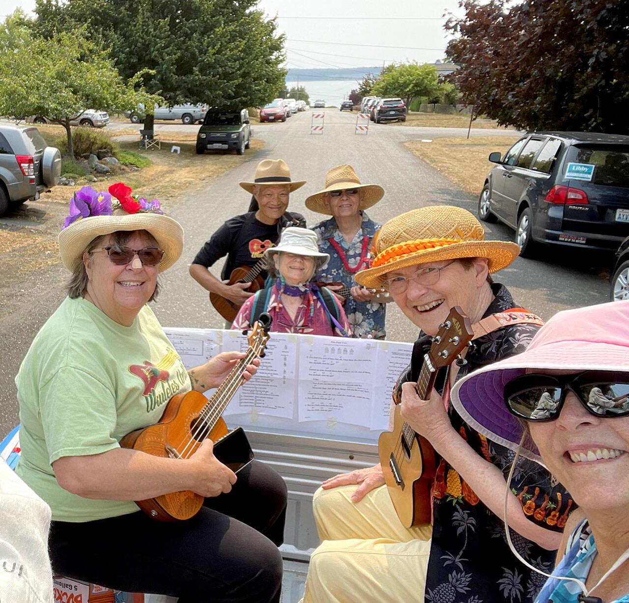 From left, Patricia Bolen, Geoff Fong, Anne Ficarra, Walter Vaux, Debbie Littlejohn and Terri Alexander ride on the Ukuleles Unite float, preparing for the August 2021 Rhody Parade in Port Townsend. The ukulelists are part of Bolens support system as she recovers from a difficult series of events. (Ukuleles Unite)