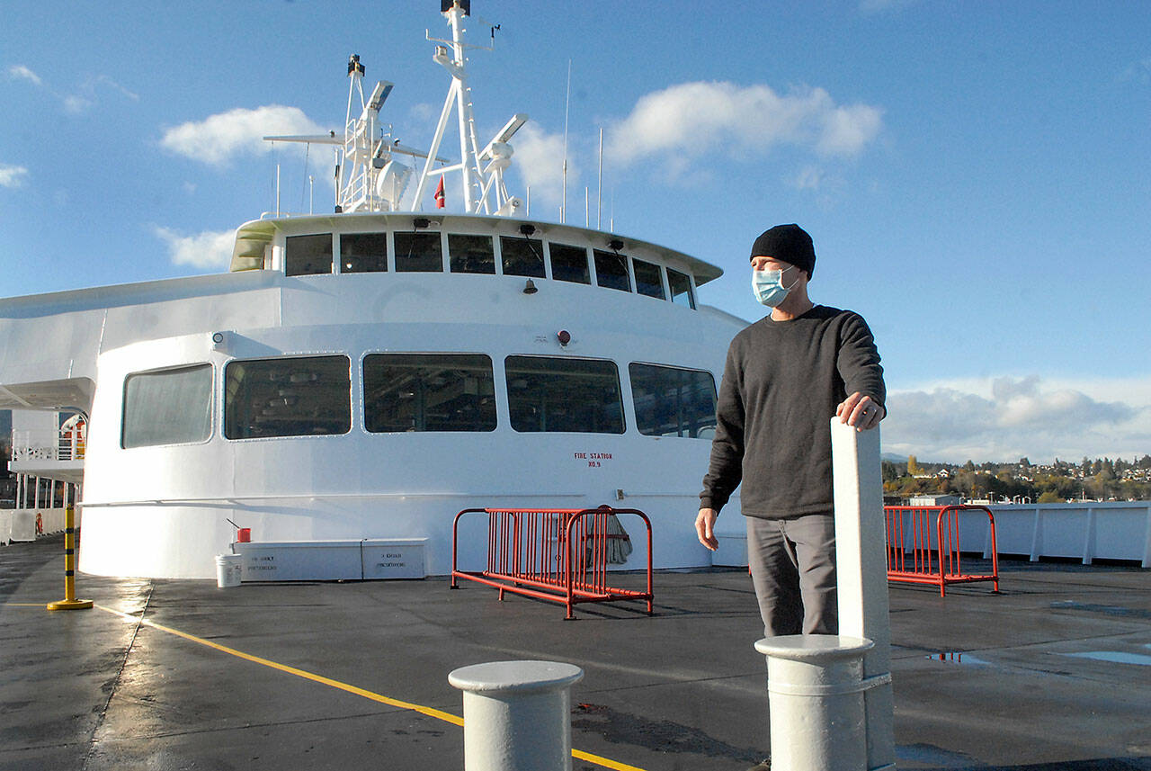 Rian Anderson, Port Angeles district manager for Black Ball Ferry Line, stands on the forward deck of the MV Coho, which will resume daily journeys across the Strait of Juan de Fuca today, 20 months after it was docked by international border restrictions due to COVID-19. The Port Angeles Chamber of Commerce plans a small send-off when it leaves for its first run at 8:20 a.m. and a large welcome of Canadians, who have sold out the ferry, at noon at the ferry terminal. (Keith Thorpe/Peninsula Daily News)