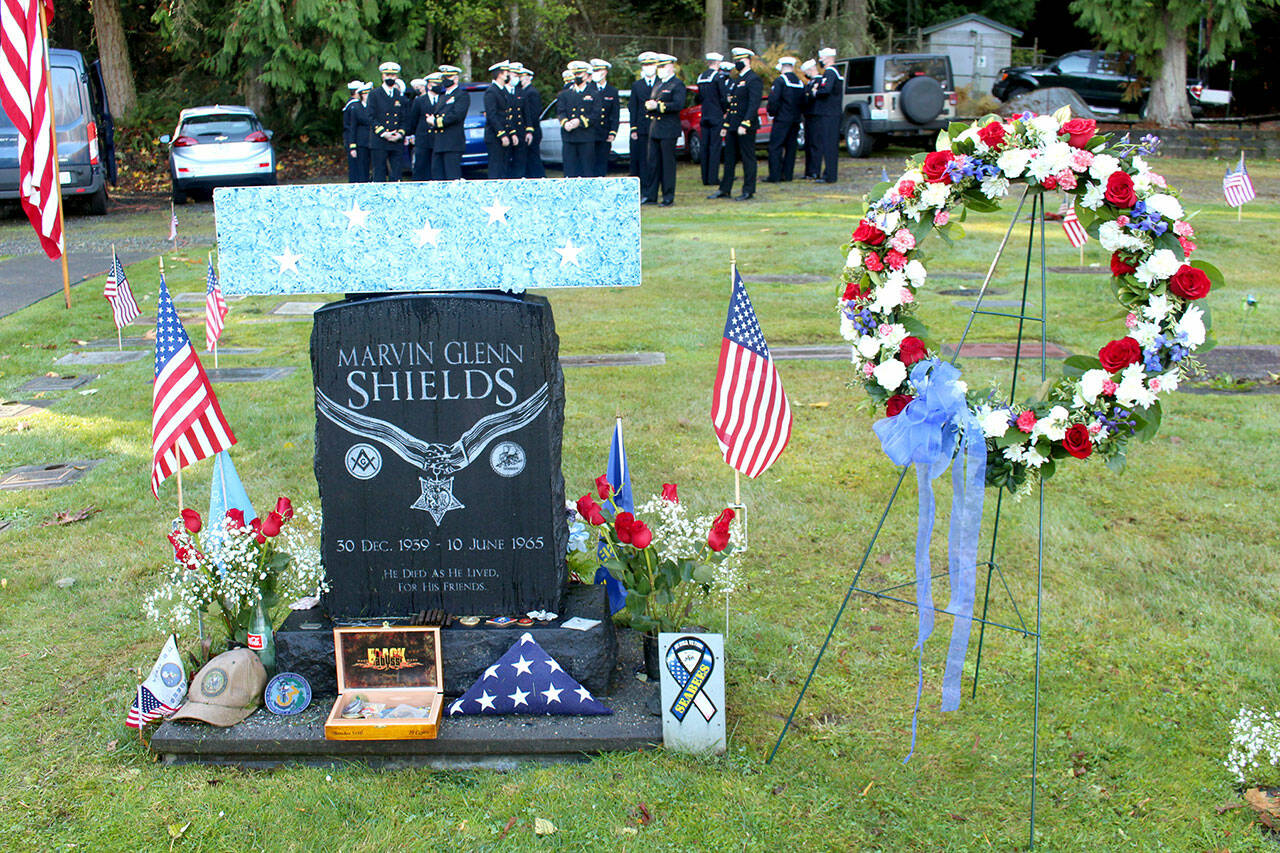 Flowers and a wreath are placed on the grave of Construction Mechanic Third Class Petty Officer Marvin G. Shields during a Veterans Day ceremony conducted Wednesday morning at the Gardiner Cemetery. (Zach Jablonski/Peninsula Daily News)