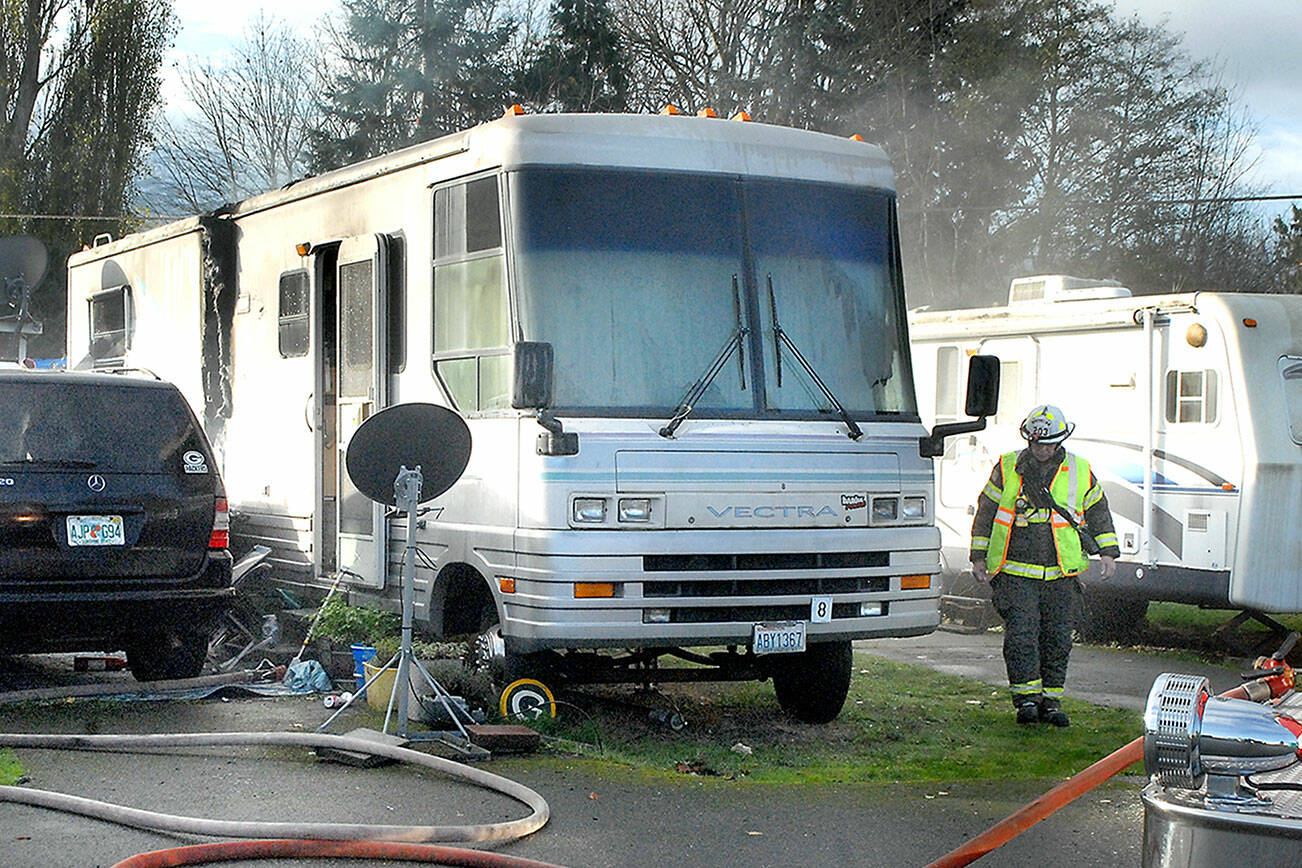 Keith Thorpe/Peninsula Daily News
Clallam County Fire District 2 Assistant Chief Dan Huff examines the scene of an RV fire at the Olympic Pines RV Park east of Port Angeles on Wednesday.