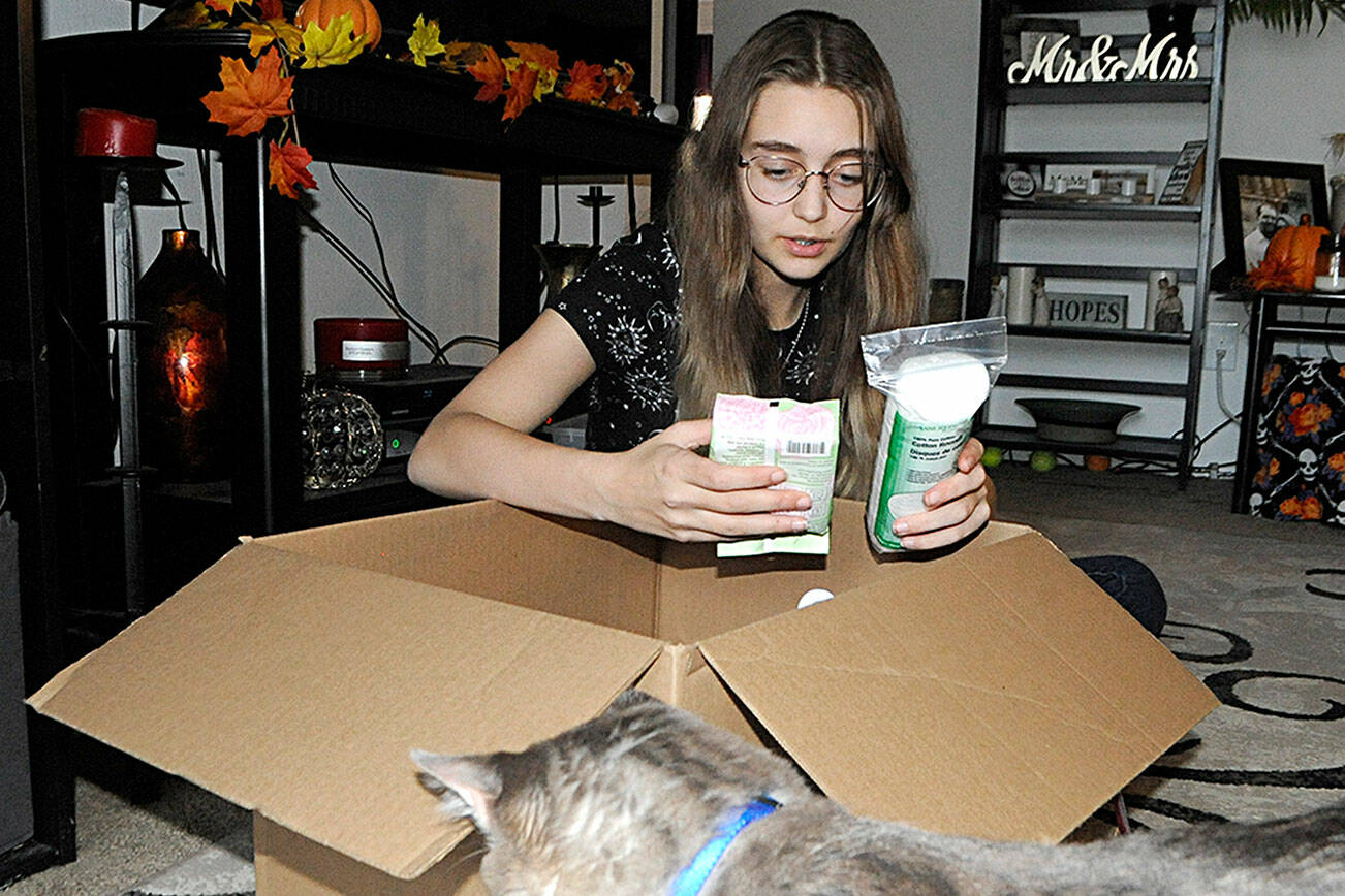 River Jensen, 15, sorts one of the many boxes of toiletries she plans to distribute to local agencies prior to Christmas. She's donated thousands of bags to in-need individuals across Clallam County. (Matthew Nash/Olympic Peninsula News Group)