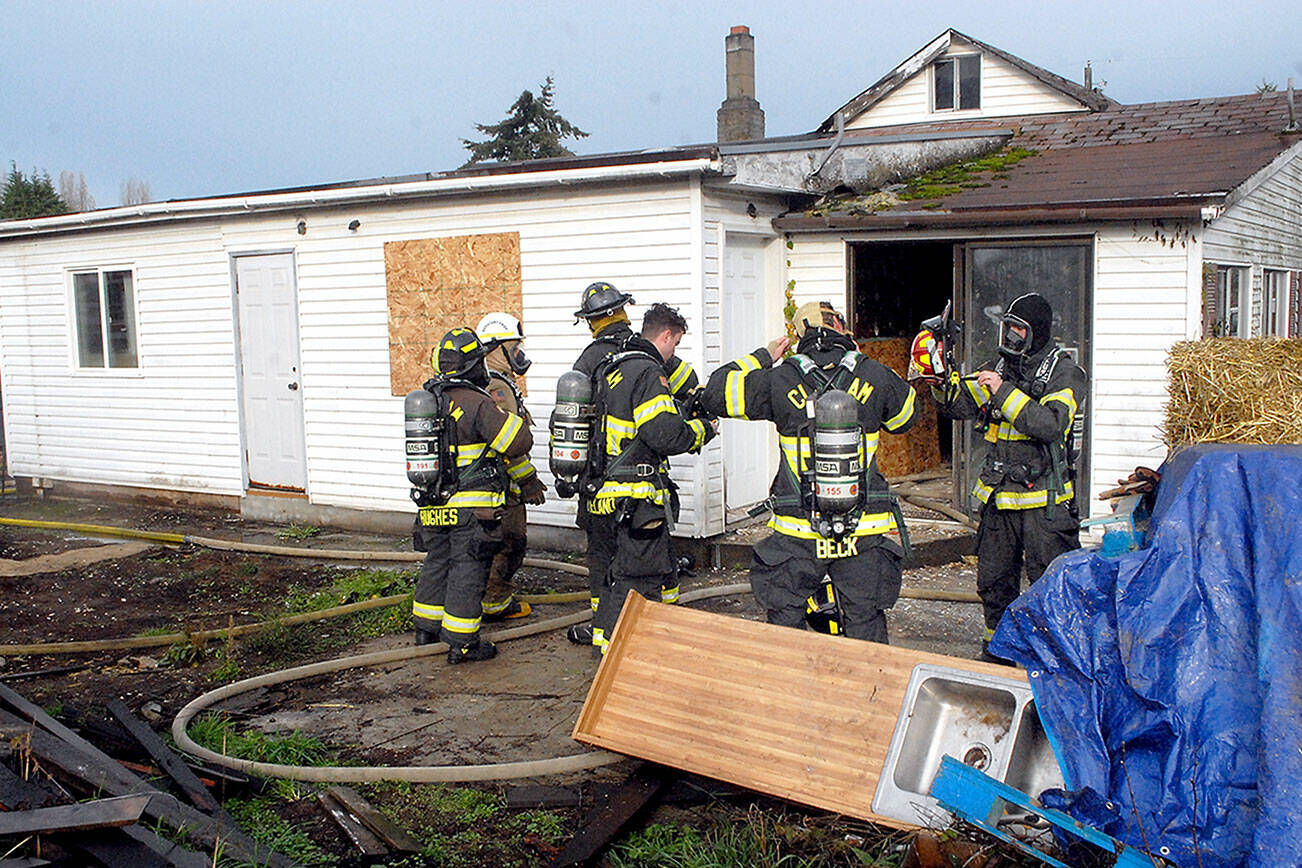 Firefighters for Clallam County Fire District 2 prepare for training on Saturday at a donated house at 2354 E. Fifth Ave. in the Gales Addition east of Port Angeles. The unoccupied house is scheduled to be used for live fire training after noon today when the structure will be ignited and burned to the ground for firefighters to hone their skills in a controlled fire situation. People seeing the blaze or corresponding smoke column are requested not to call 9-1-1. (Keith Thorpe/Peninsula Daily News)
