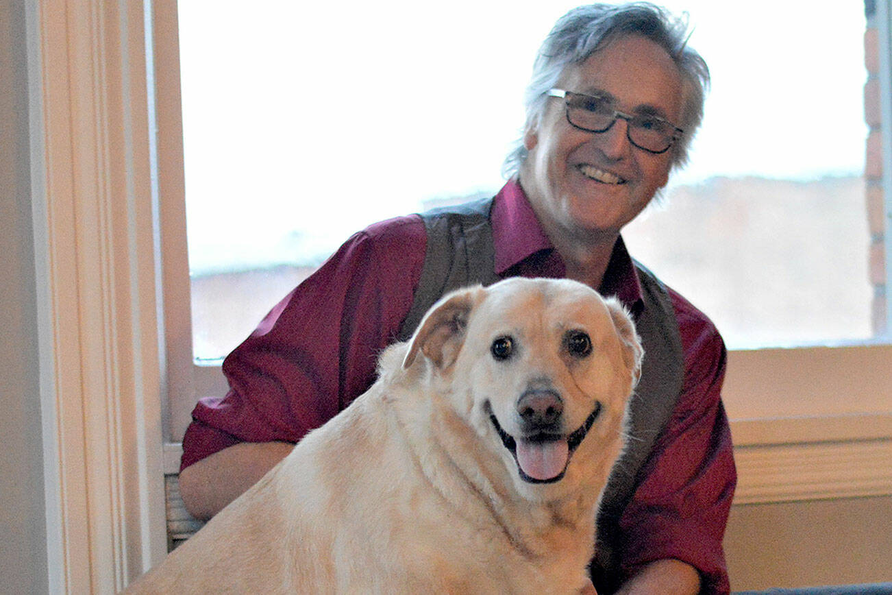Author Ward Serrill and his dog Dolly Parton, 7, share a moment at the Starlight Room, where Serrill will give readings of  his new memoir, "To Crack the World Open: Solitude, Alaska and a Dog Named Woody." Diane Urbani de la Paz/Peninsula Daily News