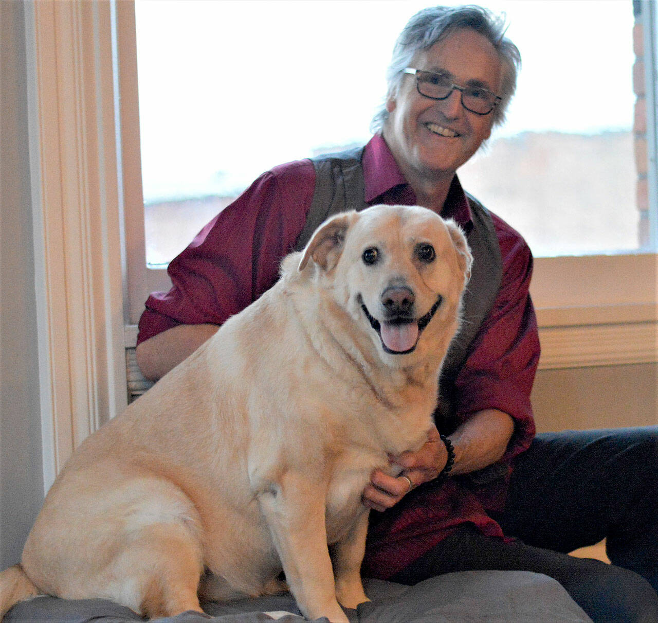 Author Ward Serrill and his dog Dolly Parton, 7, share a moment at the Starlight Room, where Serrill will give readings of his new memoir, “To Crack the World Open: Solitude, Alaska and a Dog Named Woody.” (Diane Urbani de la Paz/Peninsula Daily News)
