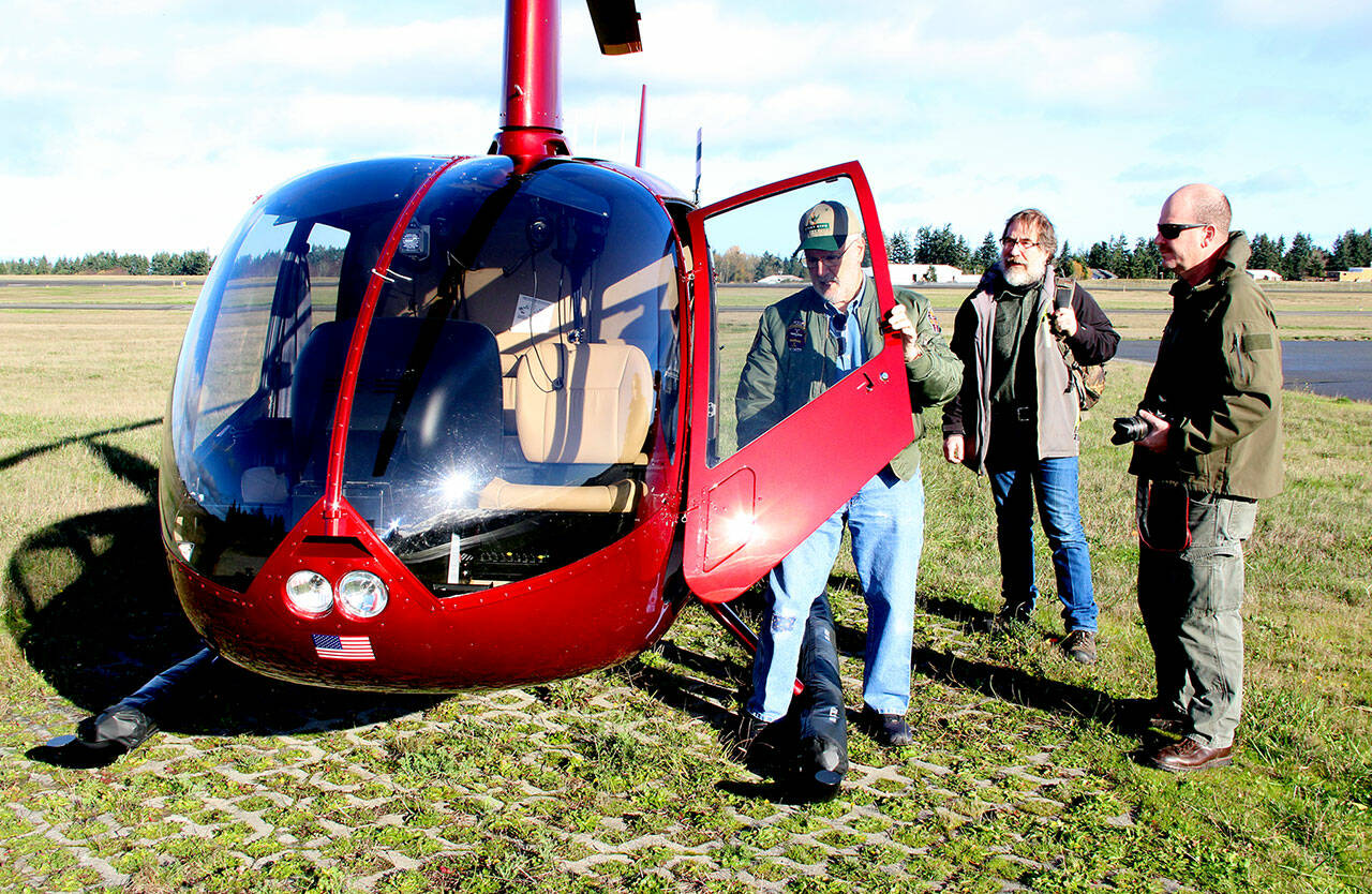 J.D. Crow, pilot and owner a helicopter used by Green Crow Co., left, prepares to board Clallam County road engineeer Joe Donisi, center, and Clallam Couny Sheriff's Sgt. John Keegan, the county's emergency  operations supervisor, for an aerial inspection of county roads on Tuesday. (Alan Barnard)