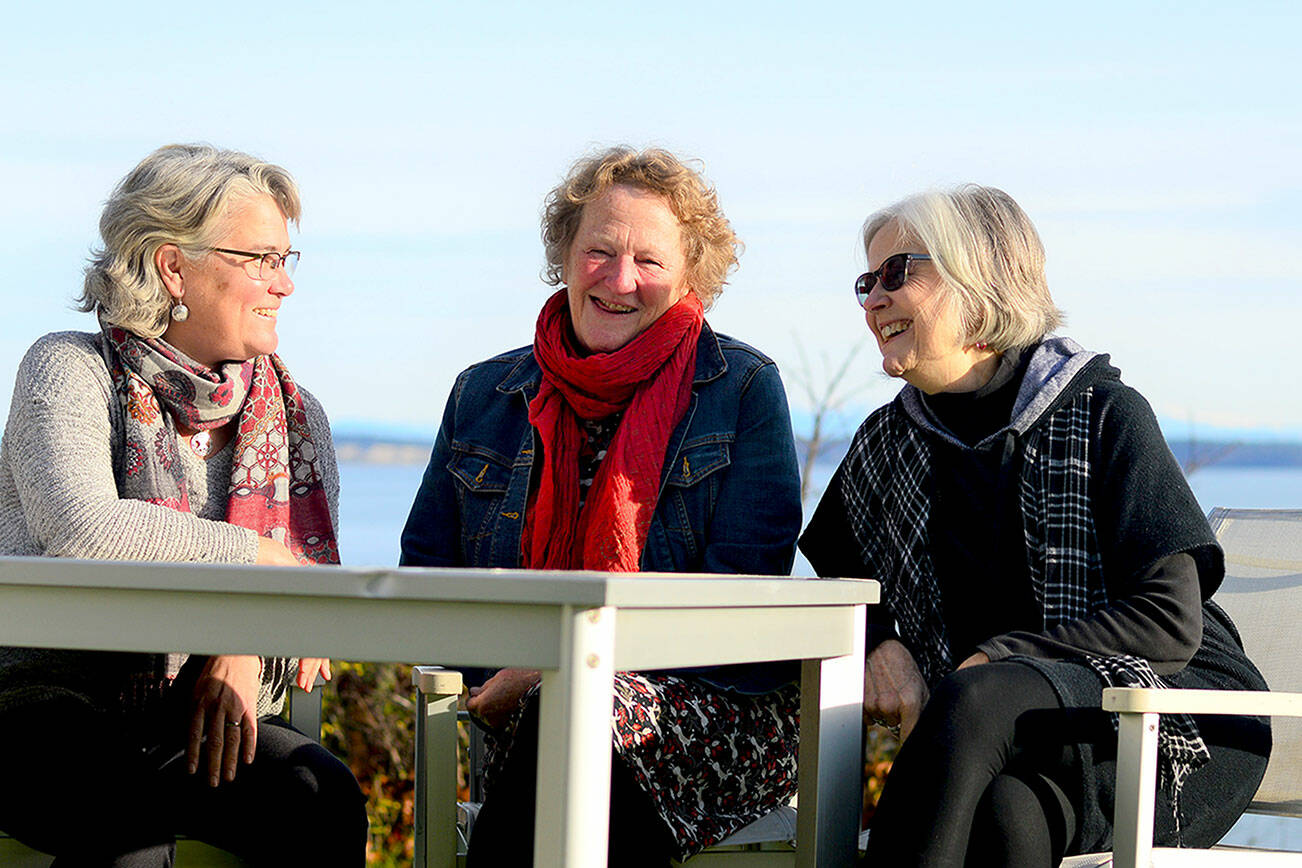 At the table where they first conceived their organization, Dying Matters Guild cofounders Carrie Andrews, left, Sarah Seltzer and Rhonda Hull talk about this weekend’s “Death, Grief and Ancestors” activities in Port Townsend. (Diane Urbani de la Paz/Peninsula Daily News)
