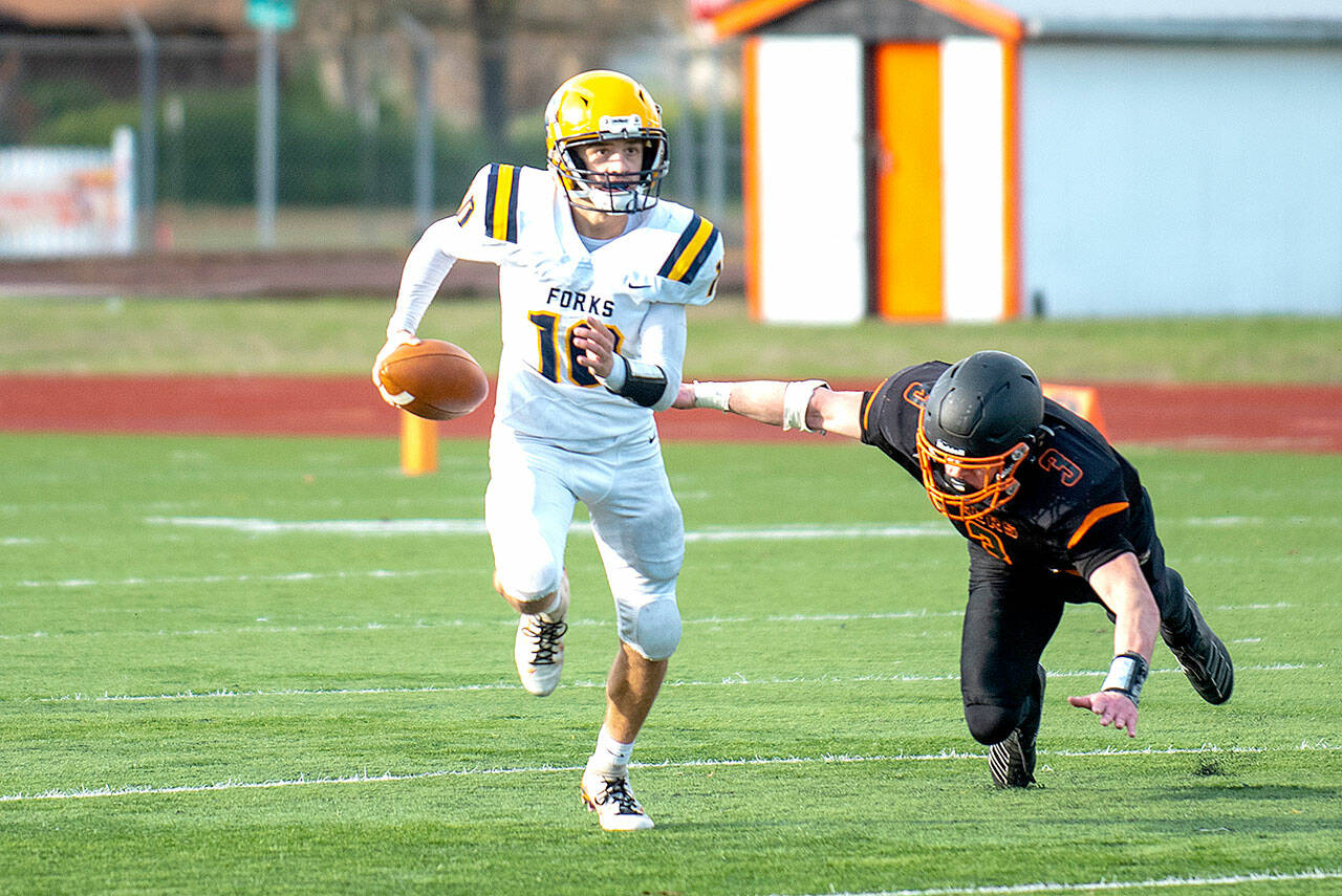 Forks quarterback Logan Olson avoids the rush against Napavine in a state 2B quarterfinal Saturday. (photo courtesy of Eric Trent/The Chronicle)
