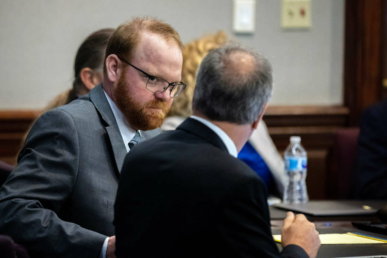 Defendant Travis McMichael speaks with his attorney Bob Rubin while they wait for the jury to return to the courtroom during the trial of McMichael and his father, Greg McMichael, and a neighbor, William Roddie Bryan in the Glynn County Courthouse, Wednesday in Brunswick, Ga. The three were charged with the February 2020 slaying of 25-year-old Ahmaud Arbery. (Stephen B. Morton/The Associated Press)