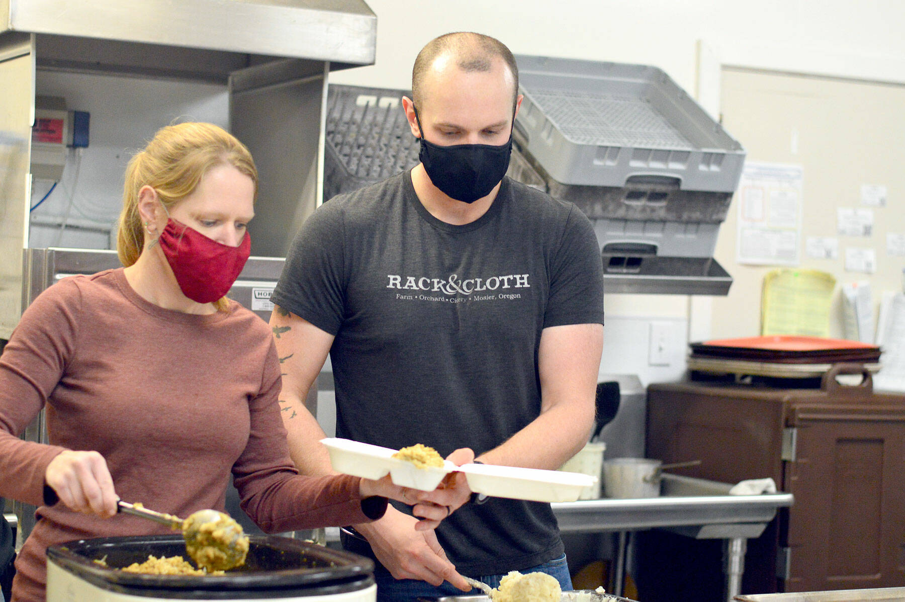 Volunteer Laura Street and her husband Matt Patterson of Gardiner were on the kitchen crew Thursday as the Tri-Area Community Center served hundreds of takeout meals. (Diane Urbani de la Paz/Peninsula Daily News)