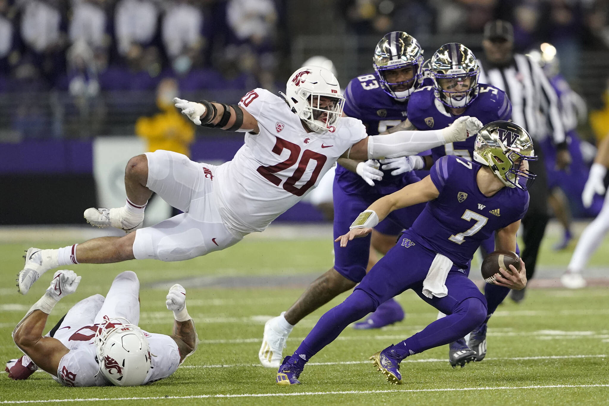 Washington State defensive end Quinn Roff (20) leaps in pursuit of Washington quarterback Sam Huard (7) during the second half of an NCAA college football game, Friday, Nov. 26, 2021, in Seattle. (AP Photo/Ted S. Warren)