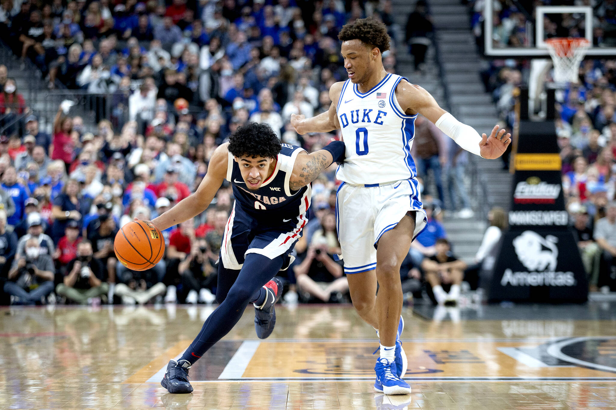 Gonzaga guard Julian Strawther, left, brings the ball up next to Duke forward Wendell Moore Jr. (0) during the first half of an NCAA college basketball game Friday in Las Vegas. (AP Photo/Ellen Schmidt)