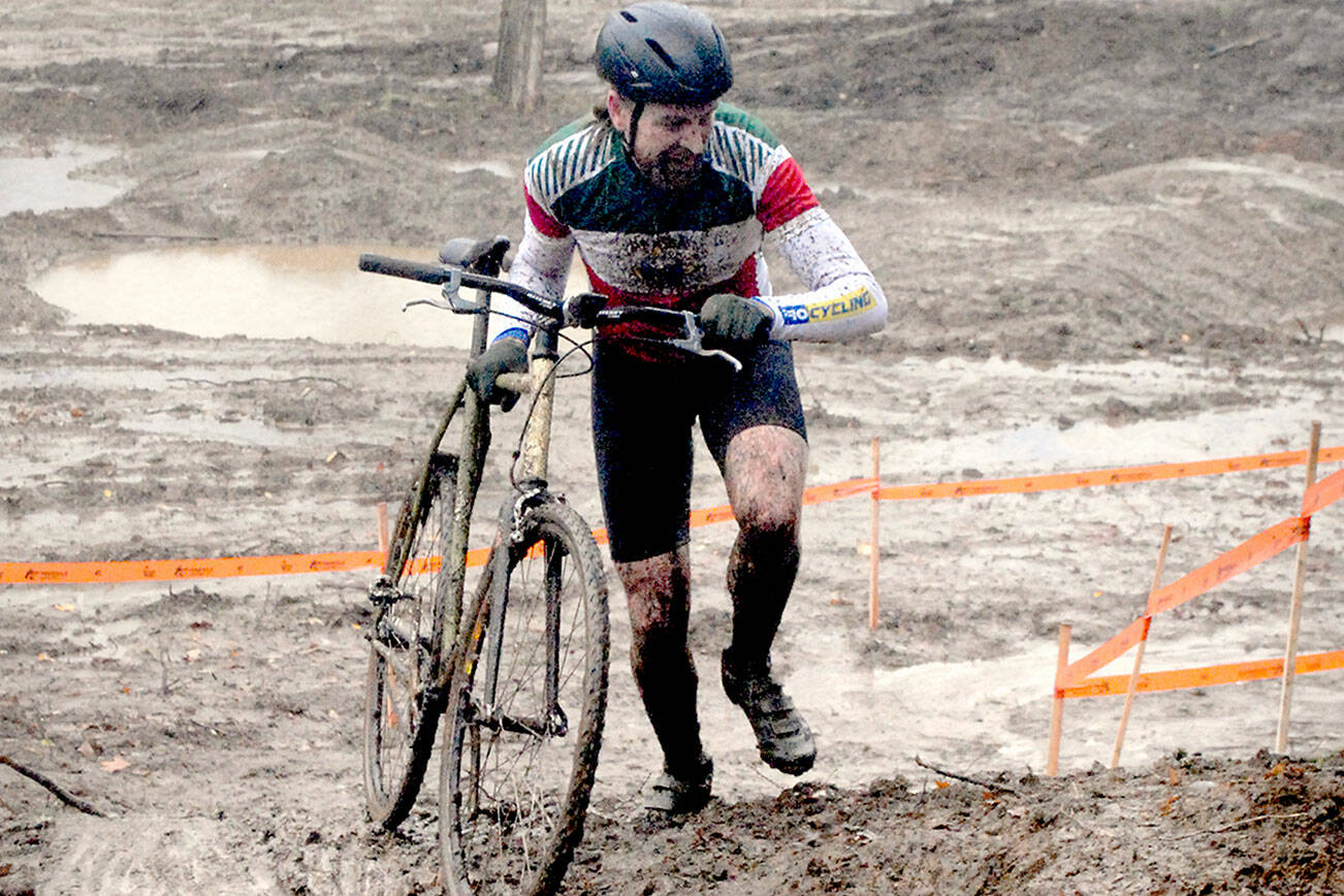 Keith Thorpe/Peninsula Daily News
Bryan Smith of Seattle pushes his bicycle up a steep, muddy hill during Saturday's PNW Extreme Cyclocross mens single-speed race at Extreme Sports Park in Port Angeles.