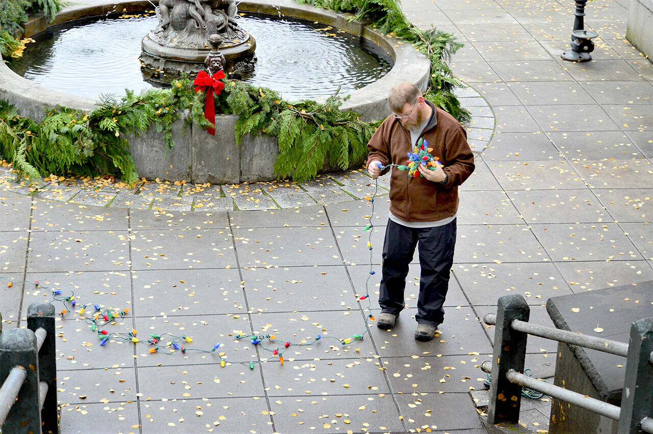 Ted Krysinski of Fyrelite Grip & Lighting worked Tuesday with thousands of LED lights that will decorate the Haller Fountain in Port Townsend.  (Diane Urbani de la Paz / Peninsula Daily News)
