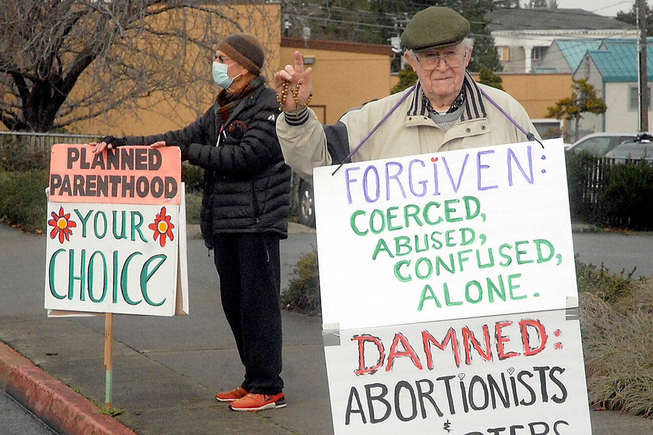 Keith Thorpe/Peninsula Daily News
Pro-choice supporter Brian Hogan of Port Angeles, left, stands near pro-life supporter Jim Hanley oif 'Sequim across from Planned Parenthood in Port Angeles last week.