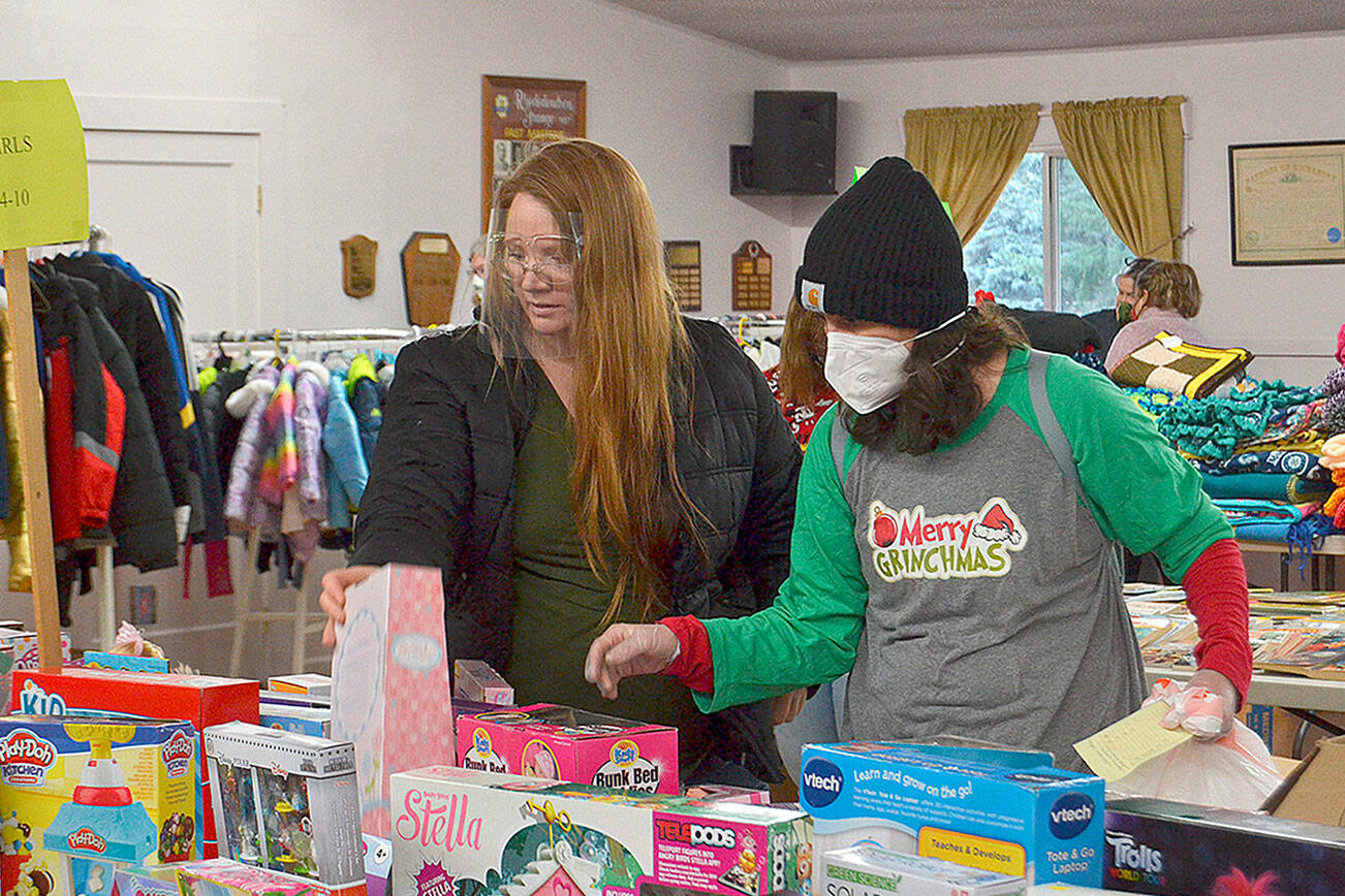 Volunteer Kirsti Turella helps Desirae Cortez look for just the right toy for her children in 2020 at Toys for Sequim Kids. The Sequim Community Aid sponsored event takes place Dec. 15 at Sequim Prairie Grange. (Matthew Nash/Olympic Peninsula News Group)