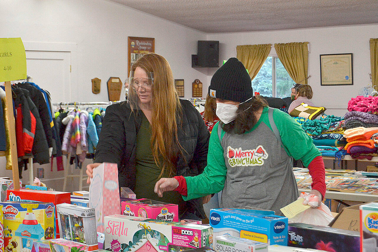 Volunteer Kirsti Turella helps Desirae Cortez look for just the right toy for her children in 2020 at Toys for Sequim Kids in December 2020. The Sequim Community Aid sponsored event takes place Dec. 15 at Sequim Prairie Grange. (Matthew Nash/Olympic Peninsula News Group)