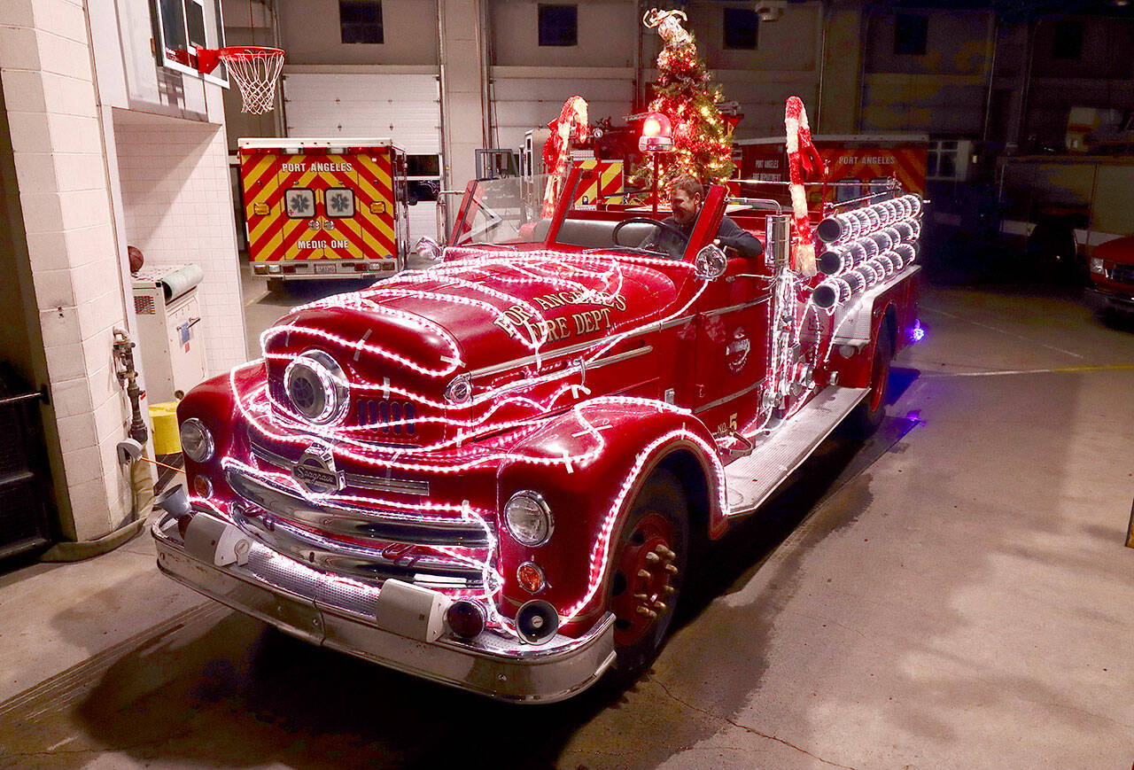 Mark Karjalainen checks out the controls of the freshly decorated 1956 Seagrave Fire Engine ready for the return of Operation Candy Cane in 2021. (Dave Logan/For Peninsula Daily News)