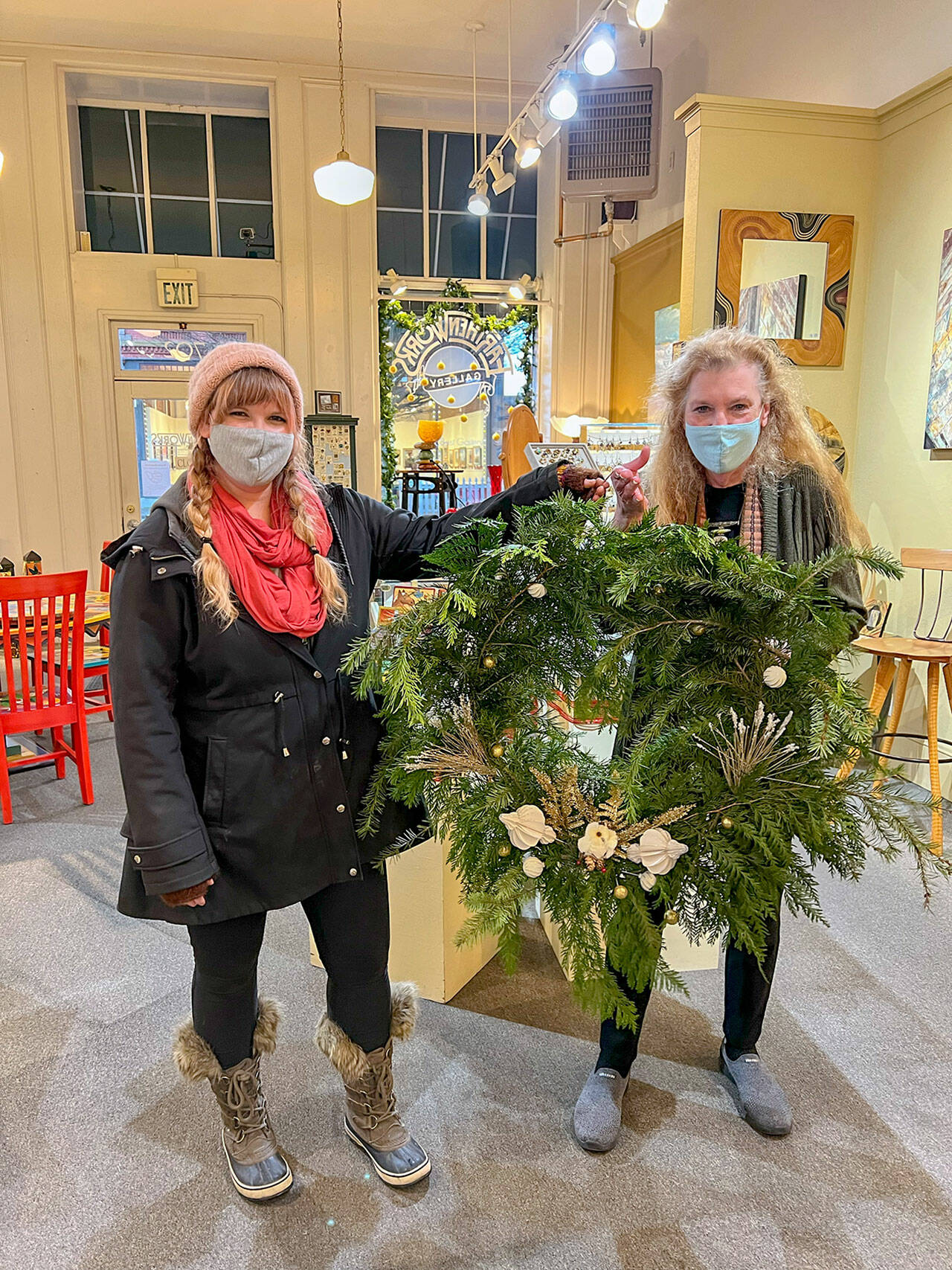 Eryn Smith, left, presents a gold award to JoAnn Williams for the window at Earthenworks Gallery. (Photo courtesy Port Townsend Main Street Program)
