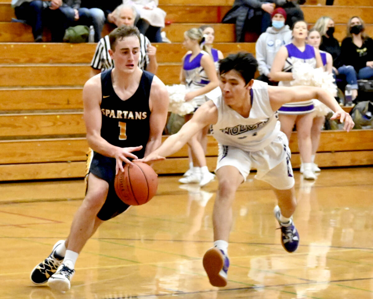 Michael Dashiell/Olympic Peninsula News Group Forks’ Riley Pursley (7) drives around the defense of Sequim’s Isaiah Moore on Friday night in Sequim. Sequim won the game 66-45.