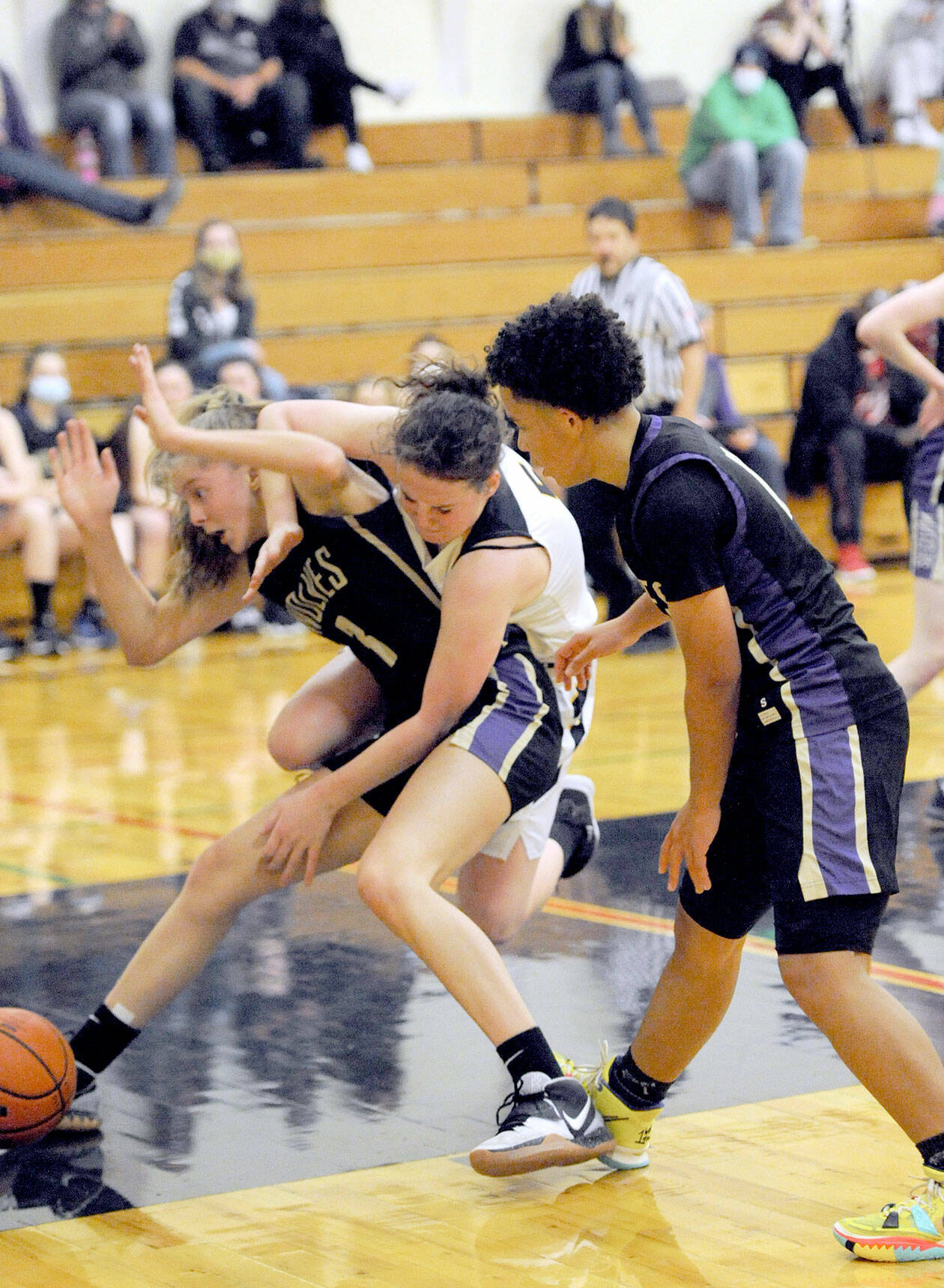 Lonnie Archibald/for Peninsula Daily News Sequim’s Sammie Bacon, left, and Forks’ Keiri Johnson battle in the key while Sequim’s Bobbie Mixon, right, looks on. The Sequim girls won 61-44.