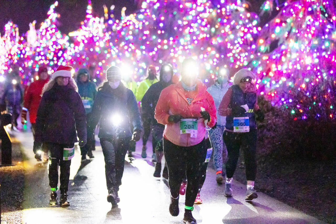 Sylvia Snell of Bremerton, No. 204, leads a pack of 5K and 10K runners in the rain to the finish line in Blyn at the Jamestown S’Klallam Glow run Saturday night. Snell ran in the 5K, along with Julie Dunlap, No. 201, at left. Kimberly DaArton, No. 500, ran in the 10K. (Run the Peninsula)